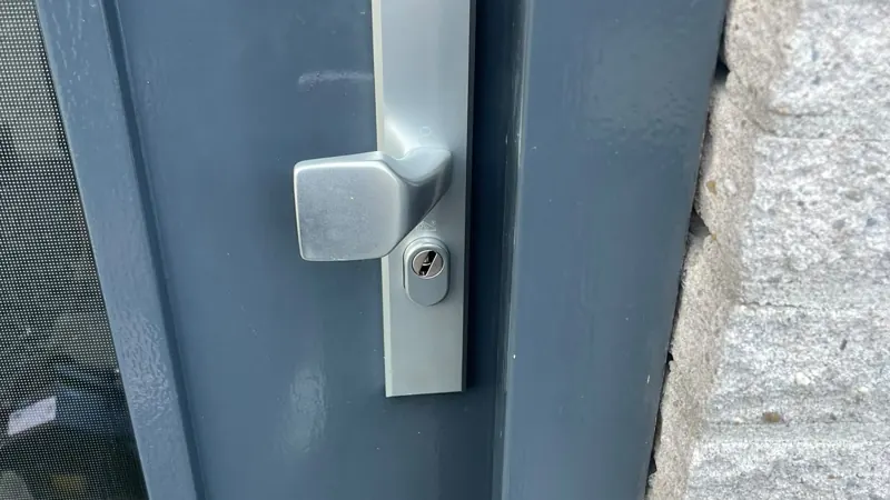 Aluminium veiligheidsbeslag met vaste knop en cilinder op een antracietgrijze buitendeur
