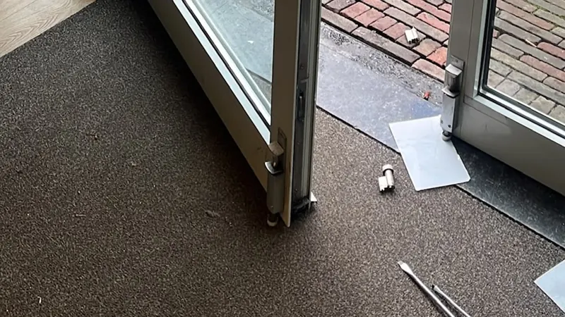 Schuifpuien Glazen pui tijdens reparatie: een deurvleugel losgenomen, onderdelen en schroevendraaiers op de vloer